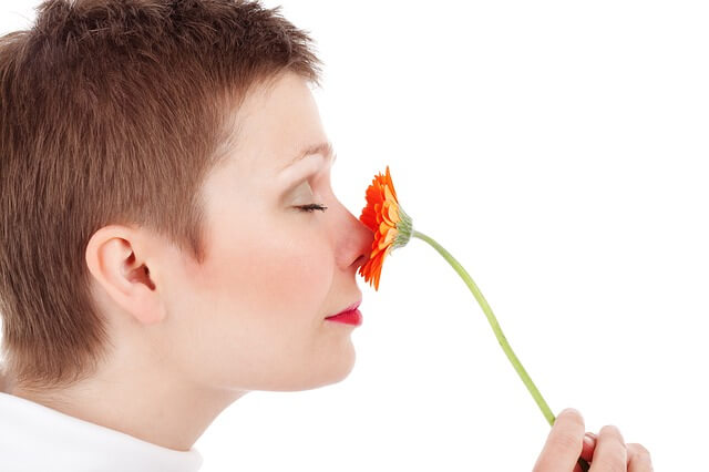 Kobieta wącha kwiatek