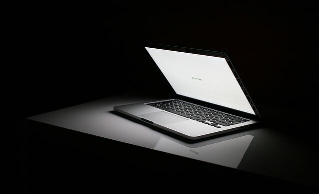 Włączony laptop leżący w ciemności