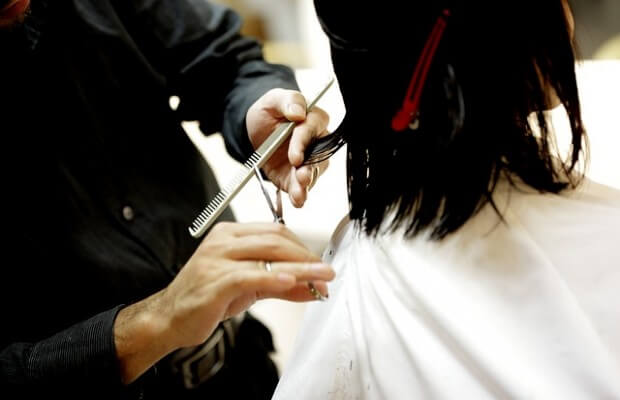 Fryzjer podcnający włosy nożyczkami